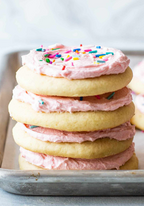 Yummy  cookie recipe for parents and teens to keep everyone happy.Stack of frosted cookies with pink icing and colorful sprinkles on a light background