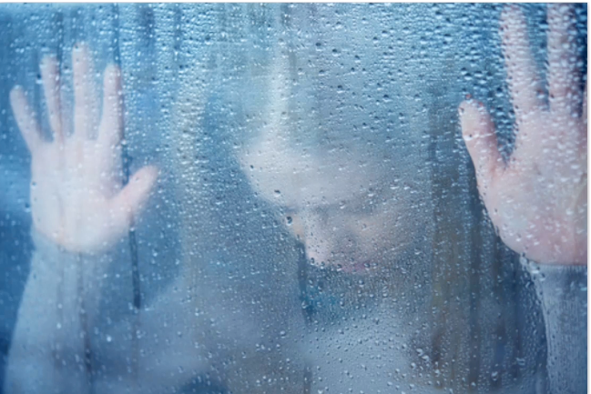 Person with hands on a foggy glass surface